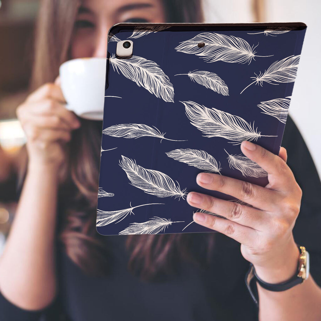 a girl is holding and viewing personalized iPad folio case with Feather design
