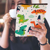 a girl is holding and viewing personalized iPad folio case with Dinosaur design 