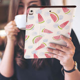 a girl is holding and viewing personalized iPad folio case with Fruit Red design 
