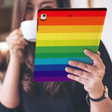 a girl is holding and viewing personalized iPad folio case with Rainbow design 