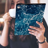a girl is holding and viewing personalized iPad folio case with Ocean design 