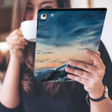 a girl is holding and viewing personalized iPad folio case with Landscape design 