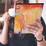 a girl is holding and viewing personalized iPad folio case with Splash design 